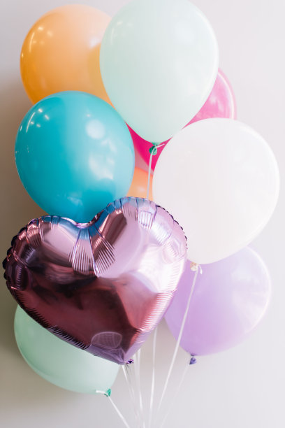灰色的墙壁背景上点缀着喜庆的五颜六色的气球图片下载
