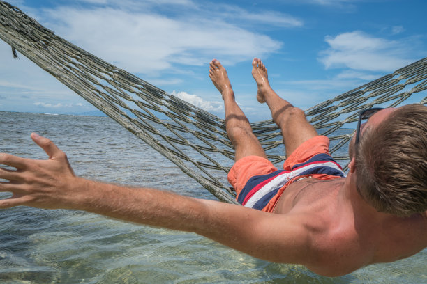 在海上吊床上放松的快乐男人图片下载