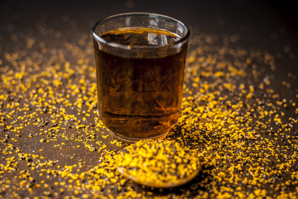 靠近拉尔萨森/棕色芥菜种子提取水在一个透明的玻璃碎芥菜种子，它是有益的/改善血液循环和免疫系统。图片下载