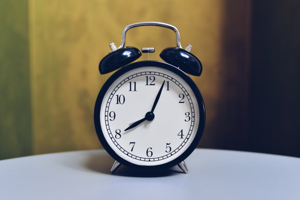 复古闹钟在桌子上与复古的颜色背景图片下载