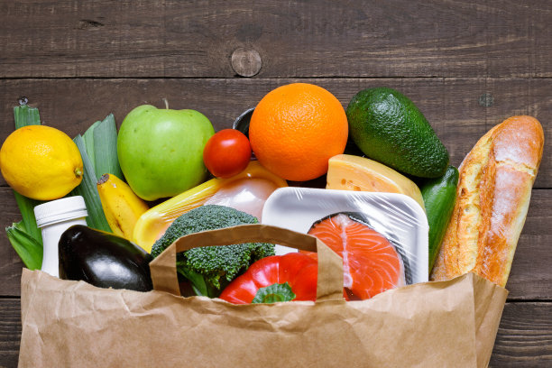 不同的食物在纸袋在乡村木制背景，图片下载