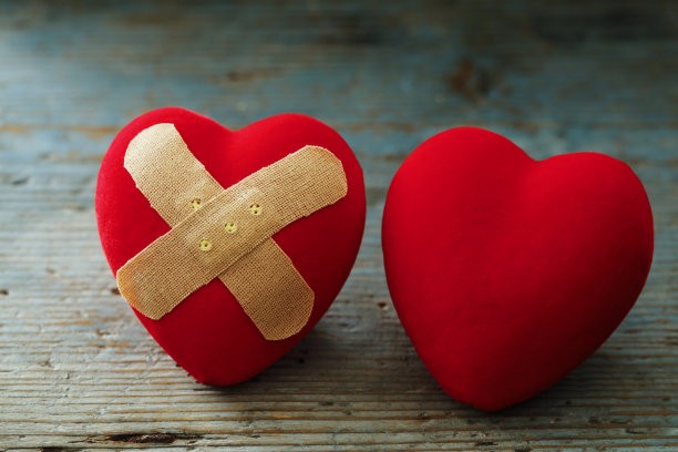 蓝色木头背景上的心脏创可贴图片下载