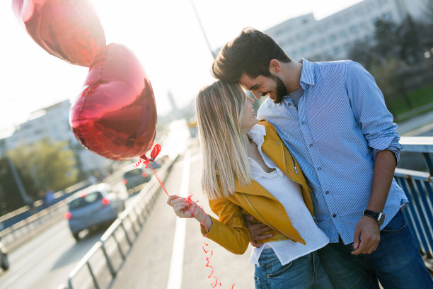 情侣们拿着气球站在外面的照片图片下载