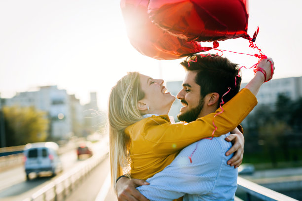 情侣们拿着气球站在外面的照片图片下载