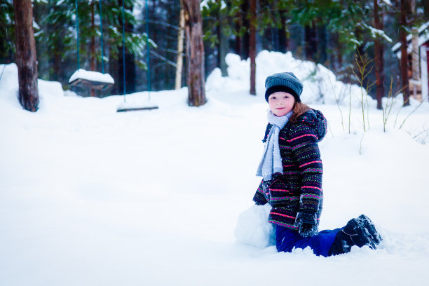女孩在院子里的雪地里玩冬天图片下载