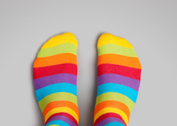 脚在彩虹颜色的袜子在灰色的背景图片下载