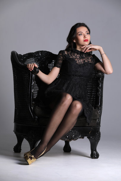 扶手椅上的女孩。灰色的背景。Photographie retouchee图片下载