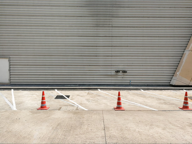 街上有白色车标和橙色锥形交通标志的停车场。图片下载