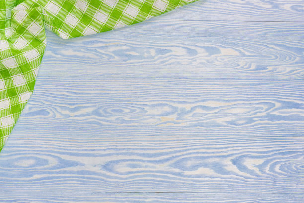 木制餐桌上的绿色毛巾。从上面看与复制空间图片下载