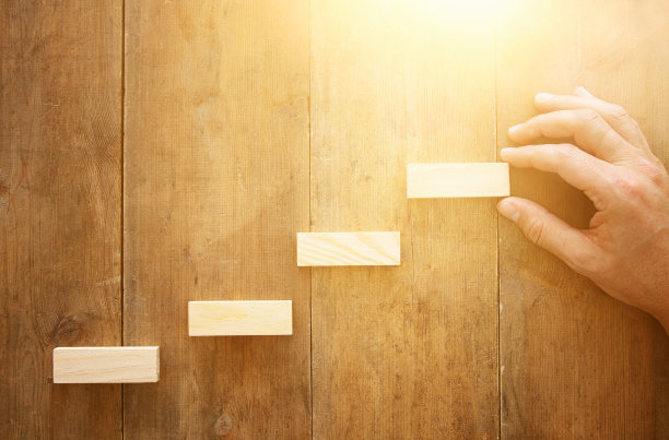 在木桌上排列木块堆叠成阶梯。业务和增长概念。图片下载
