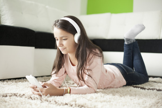 戴耳机的女孩用智能手机听音乐图片下载