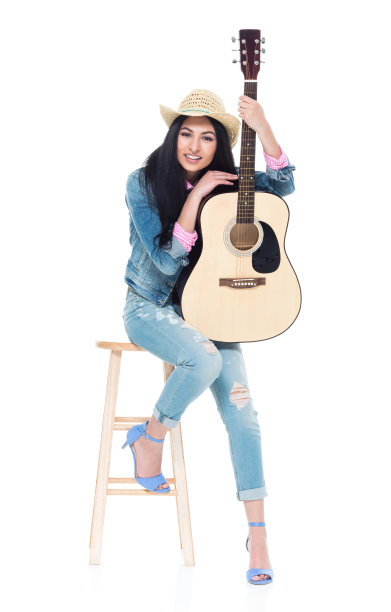 年轻漂亮的拉丁美洲女人拿着一把原声吉他图片下载