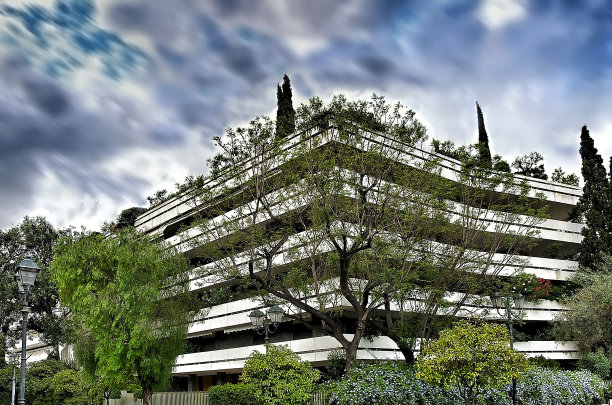 雅典市中心的公寓大楼，绿树掩映在戏剧性的天空下图片下载