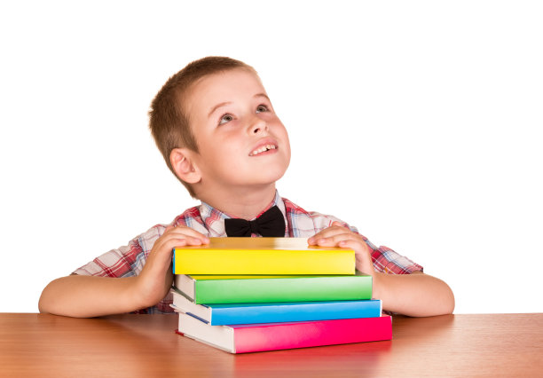 学生坐在桌子旁，书被孤立在白色的桌子上图片下载