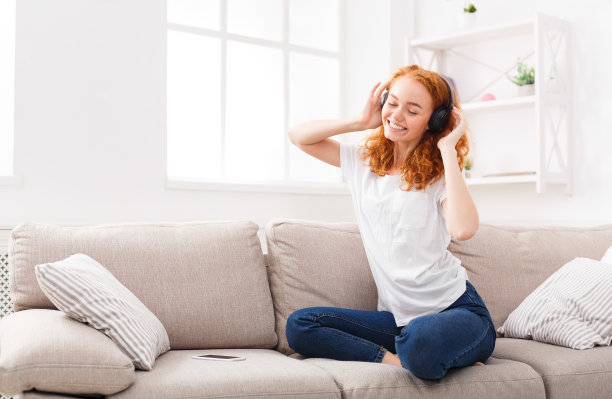 快乐的女人戴着耳机听着她最喜欢的歌图片下载