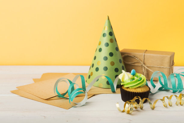 美味的纸杯蛋糕和黄色背景的礼物图片下载