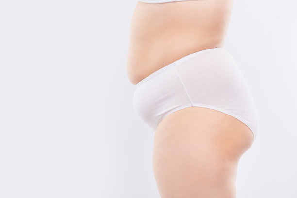 对腿部进行反脂肪按摩的概念。侧面侧面的照片，丰满的女人的腿和松弛的腹部穿着白色内裤，孤立在白色背景，复制空间图片下载