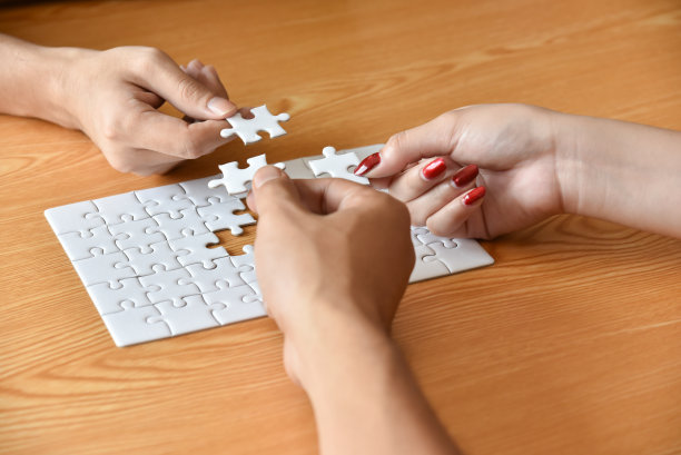 一群商界人士的手正在连接拼图。图片下载