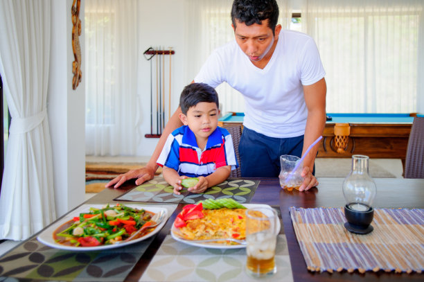 泰国男子和他可爱的儿子在家吃午饭。图片下载