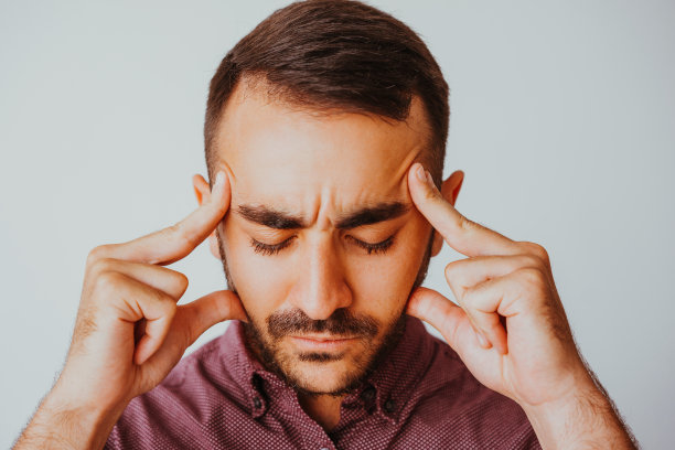 男人触摸太阳穴和努力思考图片下载