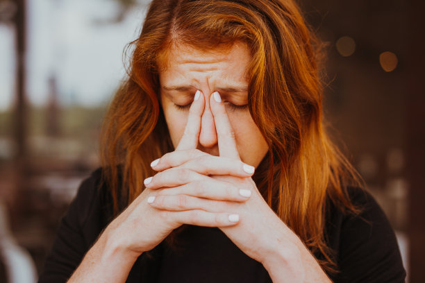 疲惫的年轻女人的手指在她的鼻梁素材图片