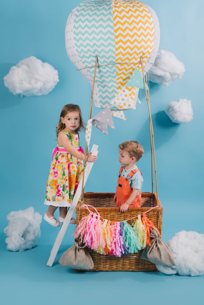 可爱的小孩子在多云的天空中假装在热气球上飞行图片下载