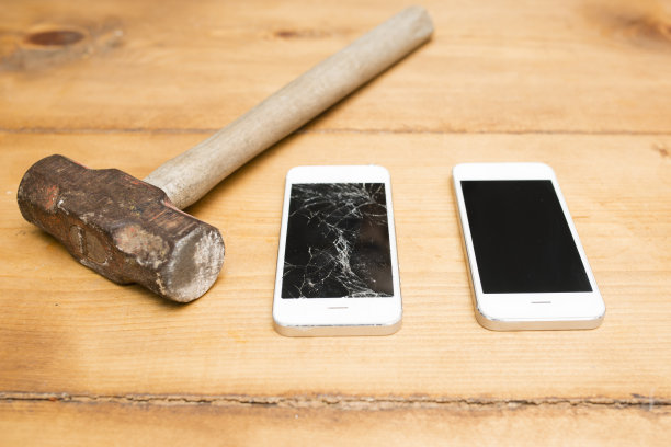 锤子和屏幕破碎的智能手机图片下载