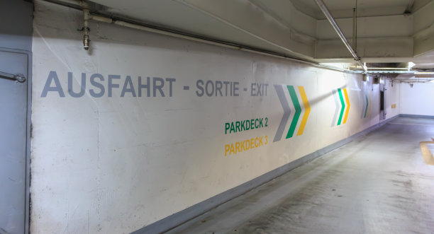 在停车场的墙上用德语、法语和英语写着“出口”图片下载