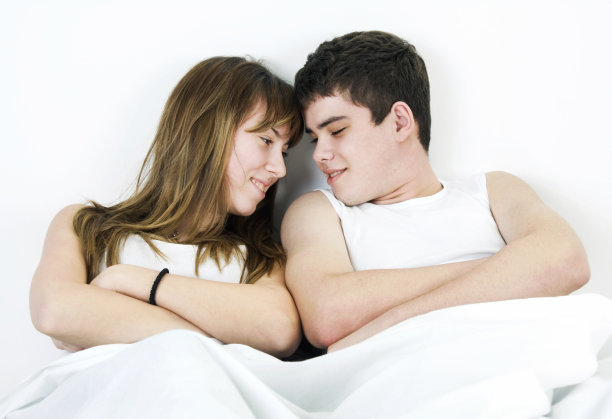 一对浪漫的年轻夫妇躺在床上图片下载