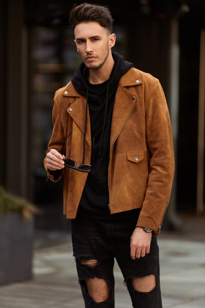 模特样的男子站在以汽车为背景的城市街道上，看他的手表和周围图片下载