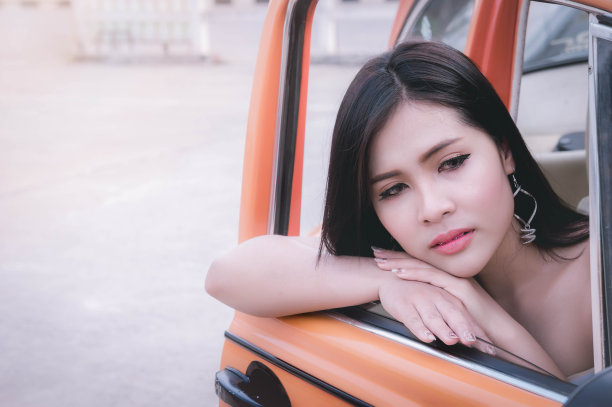 性感的女孩坐在车里独自寻找一个人或等待一个人图片下载