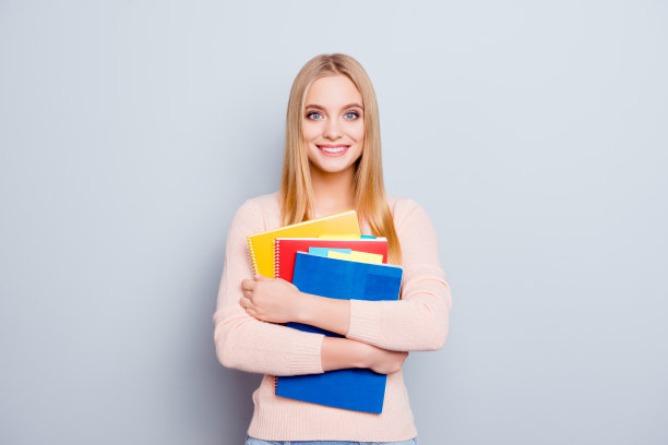 风格时尚的金发碧眼的人老师雇佣学生的概念。肖像的可爱可爱的迷人的十几岁的女孩拿着堆在书上的手孤立在灰色的背景拷贝空间图片下载