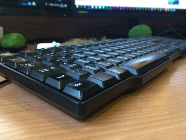 黑色键盘在工作台上，显示器在模糊的背景图片下载