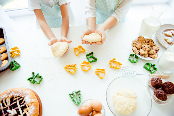 人们糕点童年厨师切割机喜悦孕妇支持信任照顾爱好朋友糖做面包活动生日概念。上面是妈妈的孩子拿生面团的手的特写照片图片下载