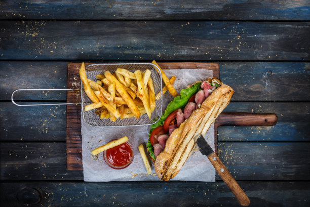 木制砧板上的大面包三明治配蔬菜和烤牛肉素材图片