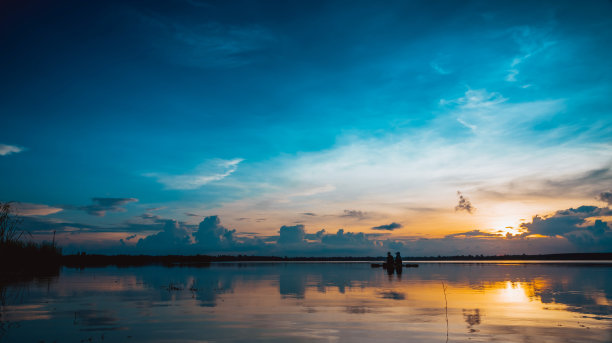 风景日落与蓝天在湖的背景和剪影成熟夫妇钓鱼图片下载
