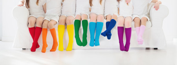 孩子们穿着五颜六色的袜子。儿童鞋。图片下载