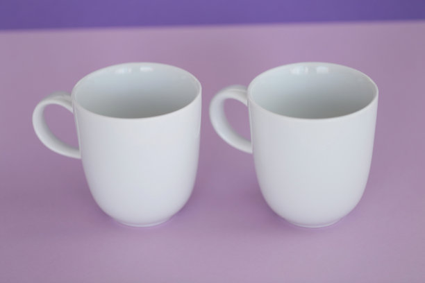 餐具模型。极简主义的杯模型。白色杯在时髦的紫色背景。图片下载