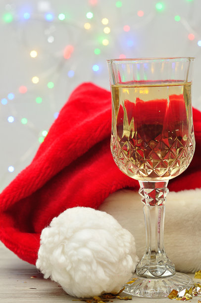 一杯香槟，上面放着圣诞老人的帽子和聚光灯图片下载