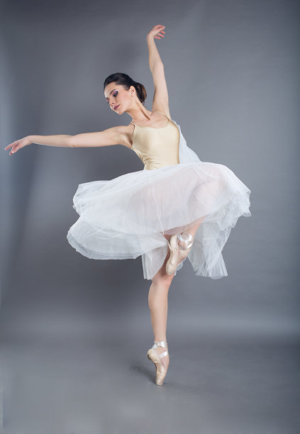 美丽苗条的女子芭蕾舞者在工作室孤立的灰色图片下载