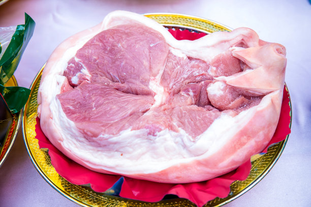 大的新鲜猪肉在盘子里。烹饪准备的原料。肉类消费的概念。图片下载