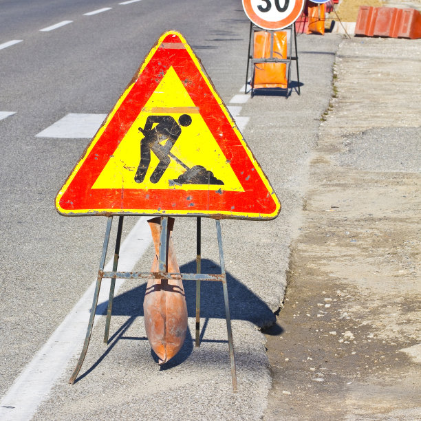 工地上的柏油路有黄色和红色的路标图片下载