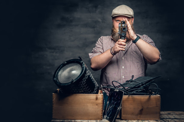 一个男人拿着一架古董相机。图片下载