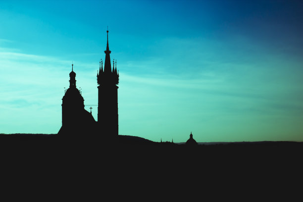 克拉科夫的圣玛丽大教堂的黑色剪影和城市中心的全景，背景是梦幻般的蓝色和湛蓝的天空图片下载