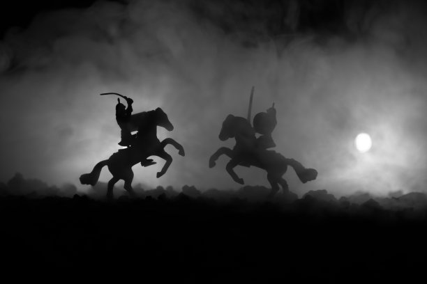 有骑兵和步兵的中世纪战斗场景。剪影的人物作为单独的对象，战斗的战士之间的黑暗色调的雾背景。夜景。图片下载