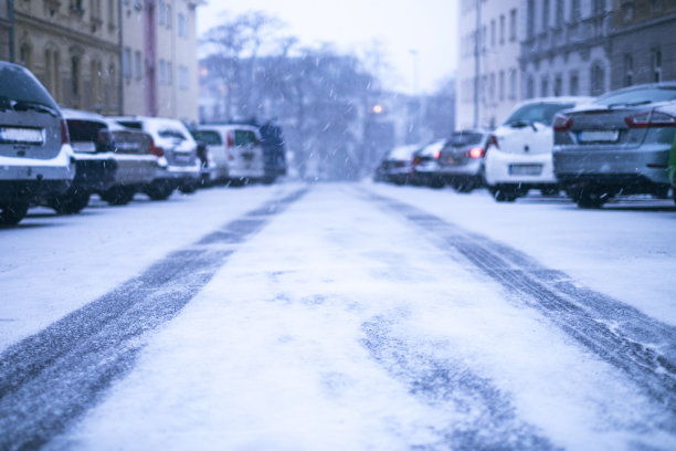 布拉格城的街道下着雪。在暴风雪路上行驶的汽车。雪灾发生在这个城市。冰雪覆盖的汽车。冬天图片下载