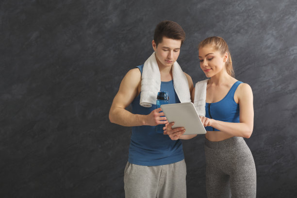 一对年轻夫妇在健身房讨论健身计划图片下载