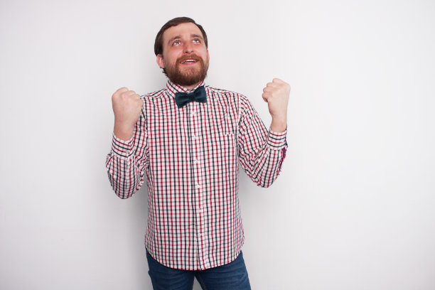 赢得的概念。年轻的大胡子男子因为强烈的兴奋而举起拳头高喊。图片下载