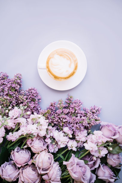 新鲜美味的卡布奇诺咖啡，上面有浓稠的牛奶泡沫，一些玫瑰，马提拉和淡紫色，淡紫色的背景图片下载