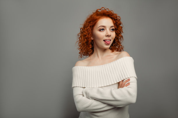 吐舌头的年轻可爱红发卷发女孩素材图片